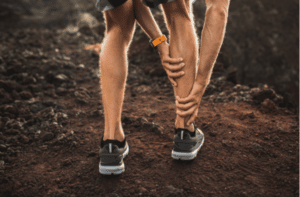 Male runner holding injured calf muscle and suffering with pain
