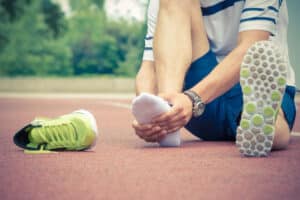 Runner rubbing foot after Lisfranc injury in Long Island, NY