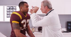 Doctor checks a football player with a concussion in NY