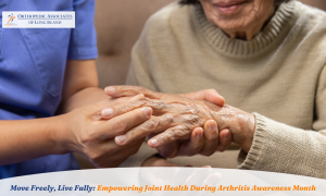 A healthcare worker gently holds the hand of an older woman, highlighting support and care, with a banner about Arthritis Awareness Month and Orthopedic Associates of Long Island.