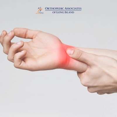OALI LP (4) A person presses on their wrist, which is highlighted in red to indicate pain or discomfort The Orthopedic Associates of Long Island logo is at the top