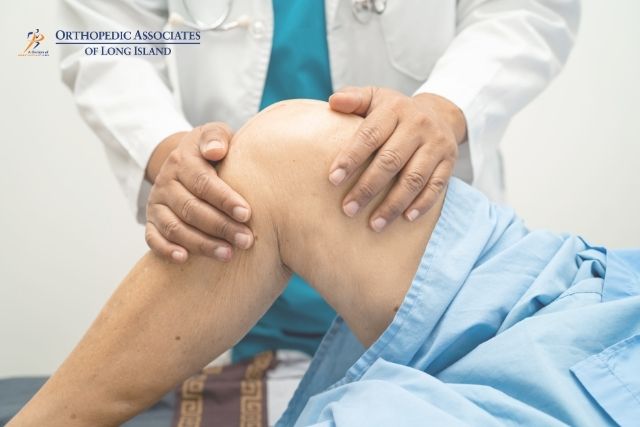 OALI LP (10) A doctor examines a patient's knee, gently holding and bending the leg while the patient lies on an exam table